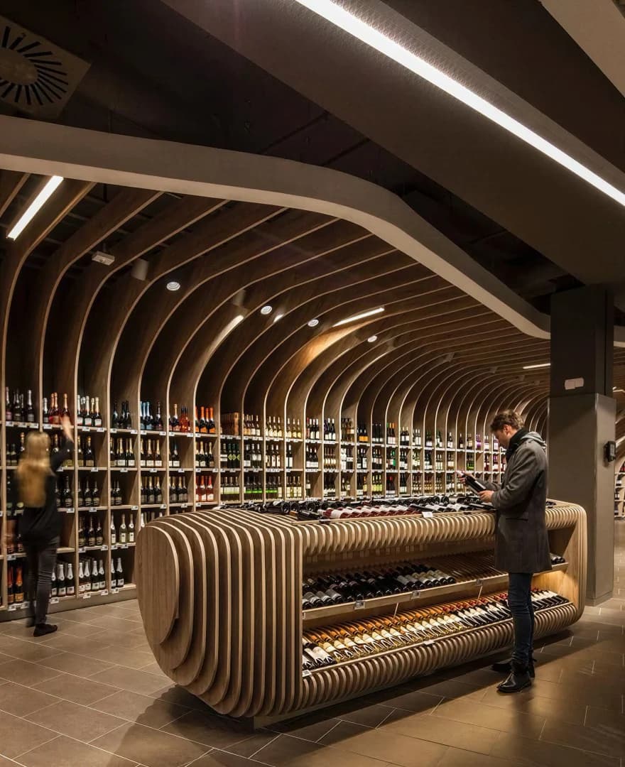 Wine shop with curved wooden rib shelving creating a tunnel-like wine display